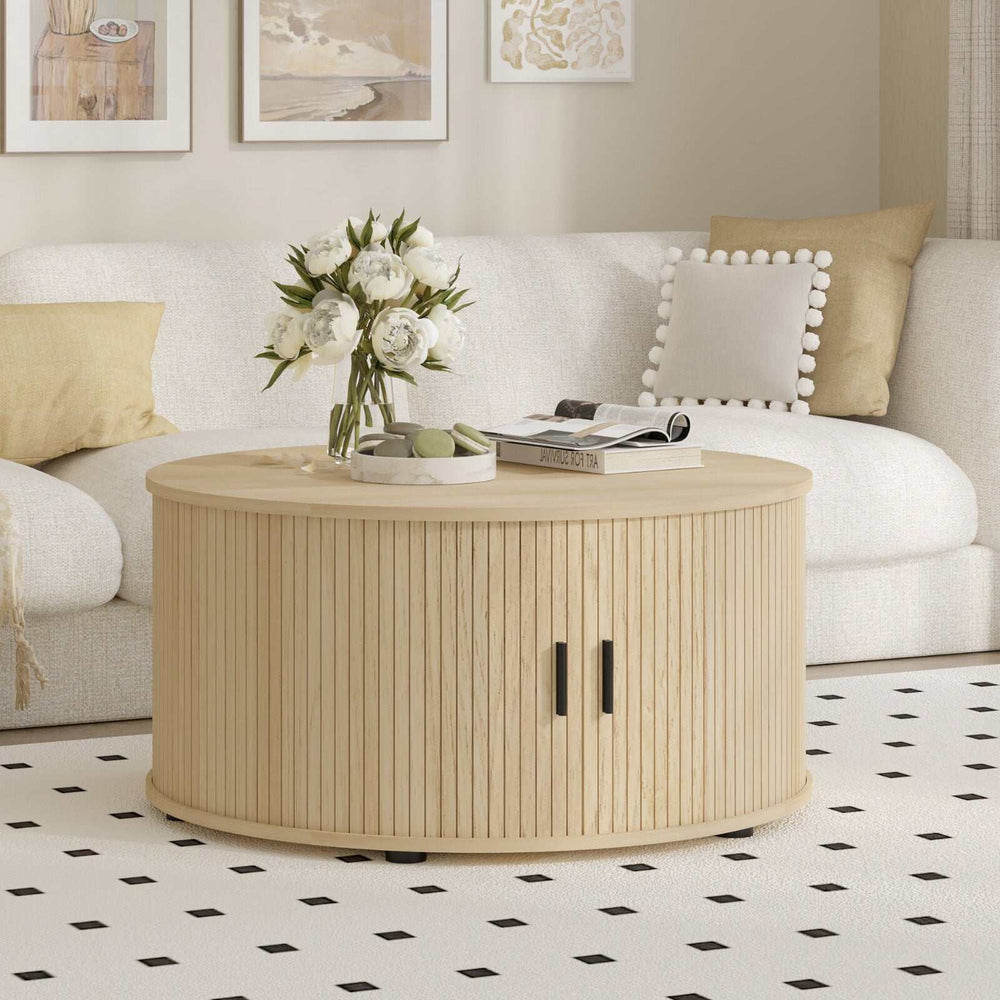 Round coffee table with light wood grain finish and fluted design, featuring a sliding tambour door for dual-layer storage.