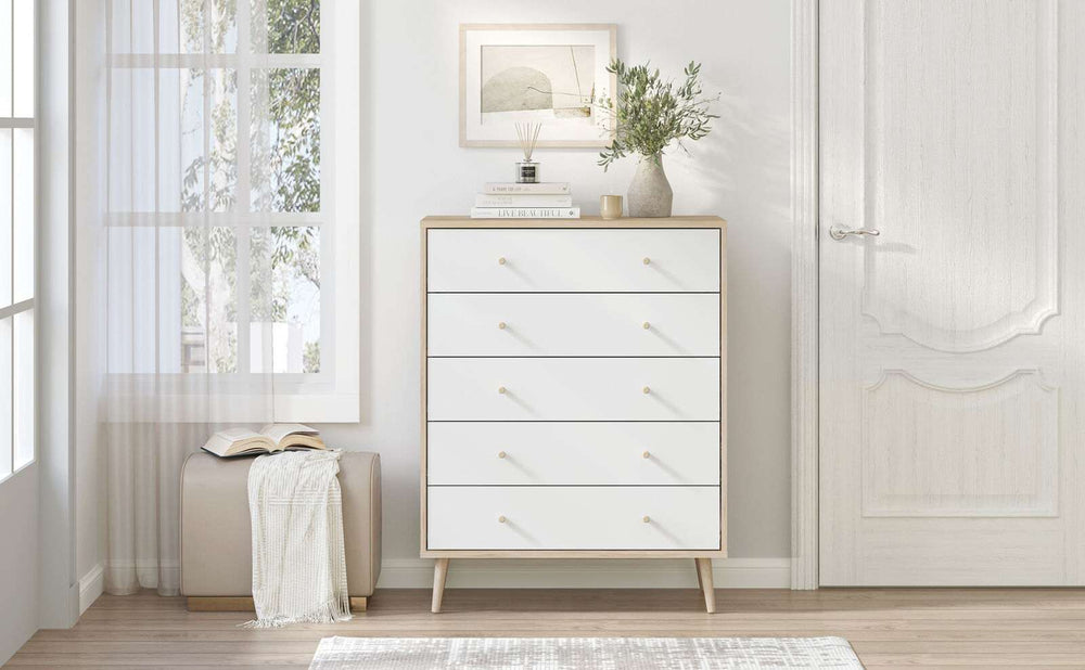 Adriana 5 Drawer chest of drawers with Scandinavian style splayed legs and oak-effect finish in a bright bedroom setting