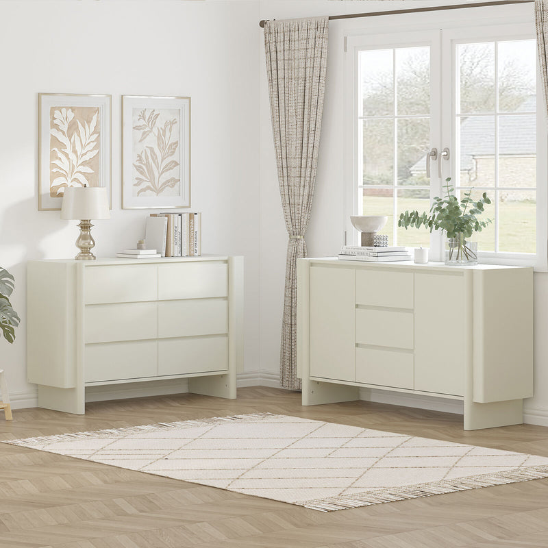 Two white dressers in a room with a window and decor.