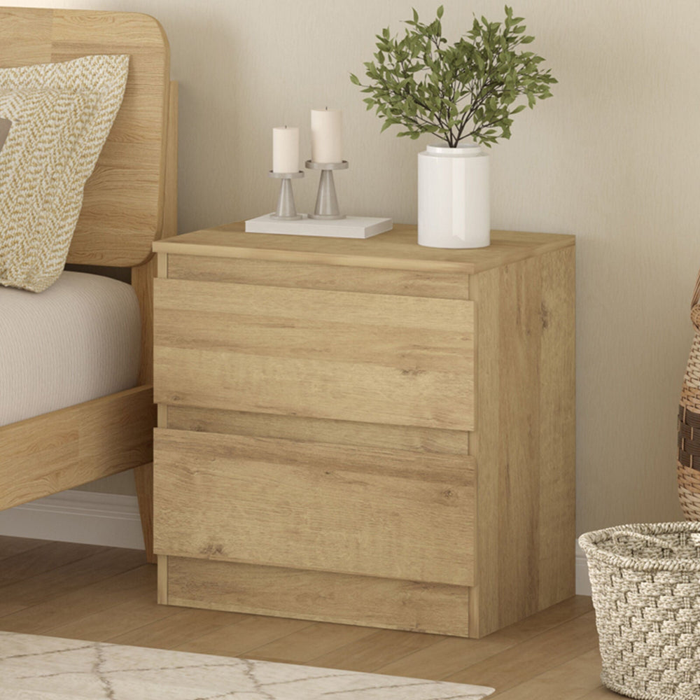 Light oak handleless bedside table with two drawers, modern minimalist design, fits various bedroom styles.
