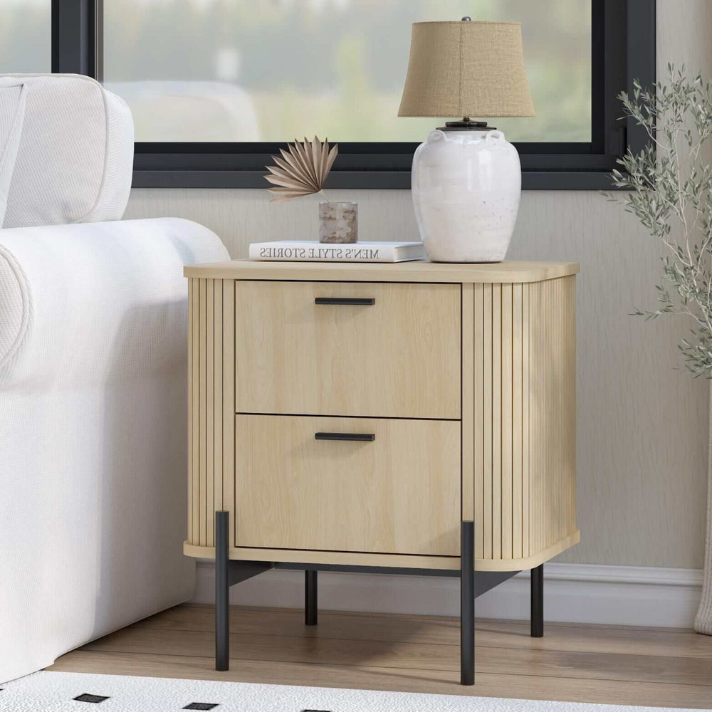 Fluted bedside table with two drawers, sleek design, and curved tambour panels, styled with a lamp and book.