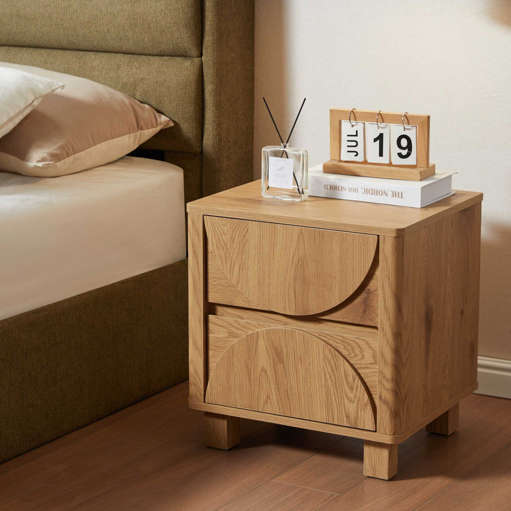 Wooden nightstand with a calendar and small plant in a bedroom setting